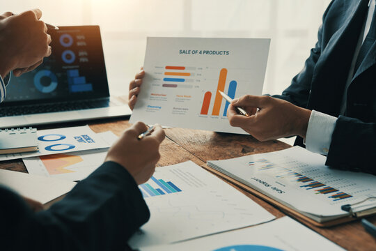 Business people discussing financial charts and graphs during a meeting, analyzing company performance and growth, using data visualization tools to make informed decisions