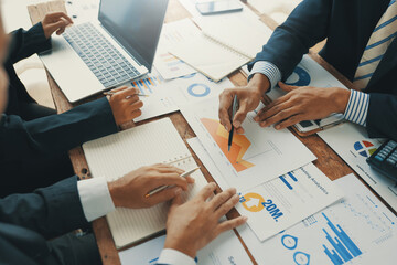 Business team analyzing marketing data and financial reports discussing company growth and planning...