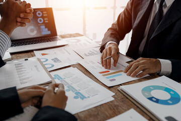 Business team engaged in analyzing financial charts and graphs, discussing company performance and...