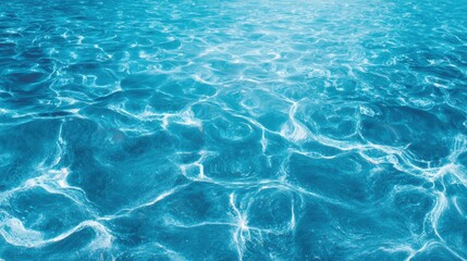 Obraz premium Bright sunlight reflects off the surface of clear blue water, creating sparkling patterns. The tranquil scene evokes a sense of relaxation and serenity near the shoreline.