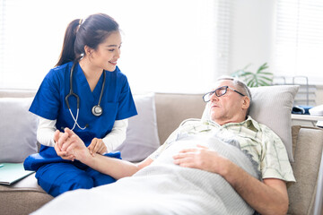 Obraz premium Female doctor or nurse taking elderly male patient's pulse, Health care for elderly patients at home