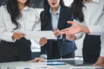 Businesswomen are discussing and analyzing financial data during a meeting in a modern office,...