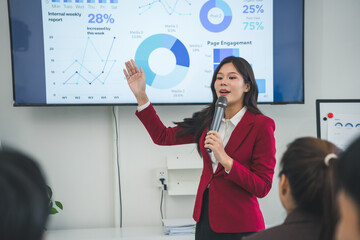 Young manager explaining company strategy during corporate meeting, pointing at charts and pie...