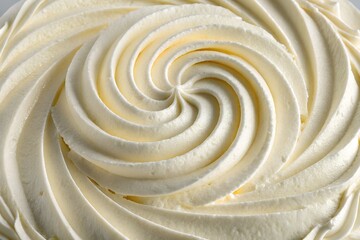 Close up of creamy white frosting swirled into a perfect spiral on a cake
