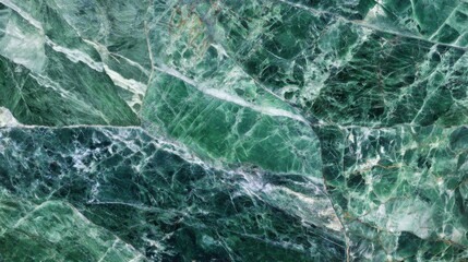 Fototapeta premium Close-up view of green marble revealing rich textures and intricate patterns. The variation in shades of green, white, and gray creates a striking natural design, ideal for decorative purposes.
