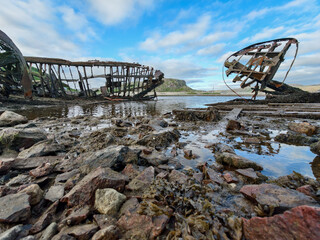 old abandoned sunken ship in the water at the ship cemetery