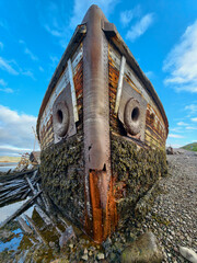 old abandoned sunken ship in the water at the ship cemetery