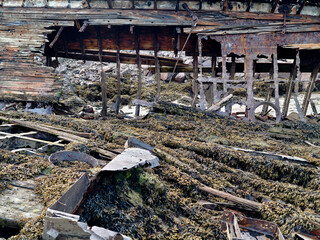 old abandoned sunken ship in the water at the ship cemetery wood pattern