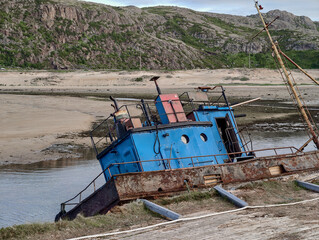 old abandoned sunken ship in the water at the ship cemetery wood pattern