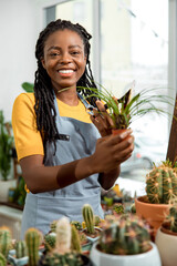 Flower shop assistant cutting flowers and looking contented and happy