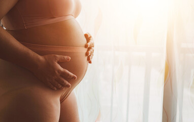 Pregnant woman holds hands on belly touching her baby caring about her health, woman pregnant, birth, preparation, maternity, care with childbirth at home.Love of family, pregnancy hold baby in belly