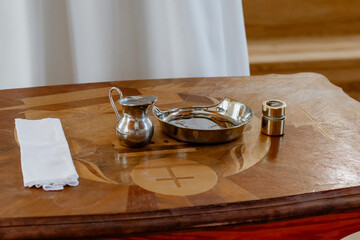 Set of Catholic Holy Vessels for Baptism or Eucharist on Wooden Altar in Church Interior