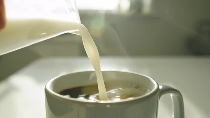 Pouring milk into coffee in slow motion for a creamy cappuccino - Powered by Adobe