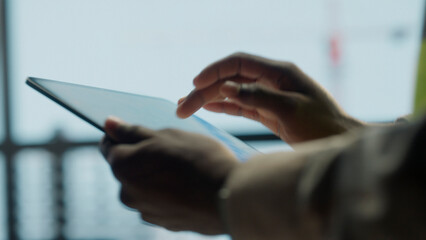 Plakat Businessman using digital tablet in modern office with city view