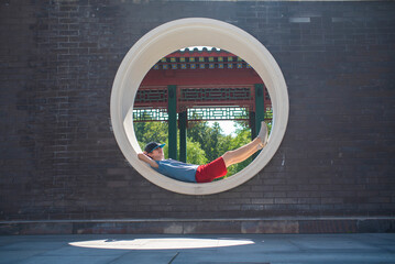 A teenage boy relaxes in the Chinese Huamin Park in Moscow in the summer.