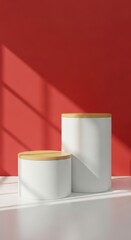 Minimalist white cylinders with wooden lids on a red background with shadows