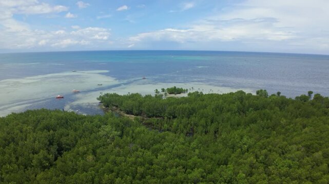 High drone sweep unveils Barimbing Beach&rsquo;s sprawling mangrove islands, anchored bancas and pale reef flats merging into the calm Sulu Sea with hazy mountains beyond.