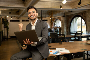 Young good-looking young manager feeling positive while working in the office