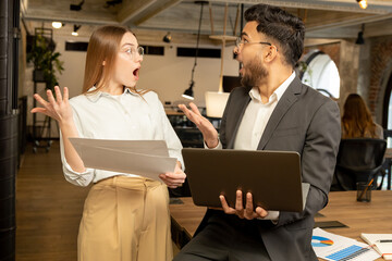 Colleagues in the office discussing project details and looking involved