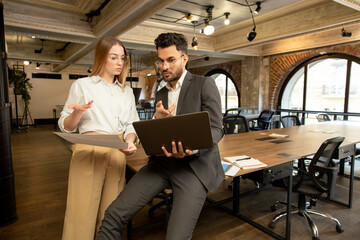 Colleagues in the office discussing project details and looking involved