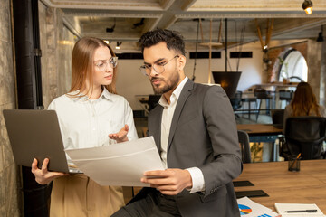 Two young professionals working in the office and looking involved