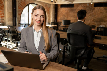Cute long-haired blonde female manager working in the office