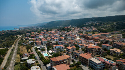 Fototapeta premium Red-Roofed Residential District with Lush Hillside – Panoramic View