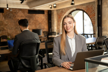 Cute long-haired blonde female manager working in the office