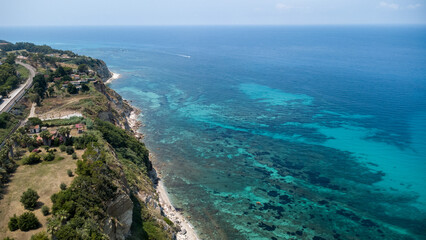 Fototapeta premium Calabrian Cliffside Road Above Turquoise Coastline – Aerial View from Southern Italy