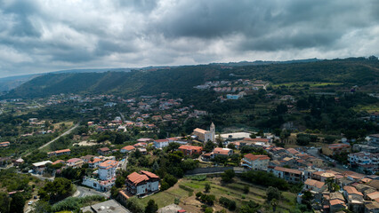 Fototapeta premium Drone View of Italian Village with Church and Hills under Dramatic Sky
