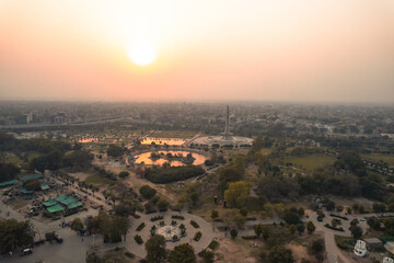 Scenic aerial view of Greater Iqbal Park, Lahore, Pakistan. Green spaces, monuments, and vibrant city skyline.
