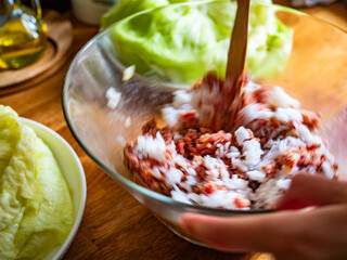 Cooking stuffed cabbages on wooden table - polish cuisine golabki