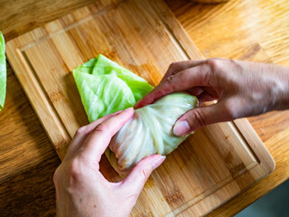 Cooking stuffed cabbages on wooden table - polish cuisine golabki