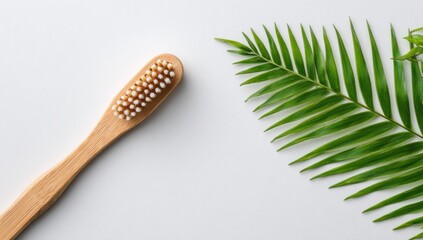 Bamboo toothbrush next to a palm frond