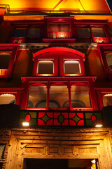 Beautifully illuminated red facade of a building at night. Architectural detail and warm lighting.