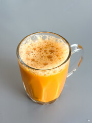 Teh tarik served in a clear glass mug, Malaysia’s iconic pulled milk tea with frothy top and rich, sweet aroma.