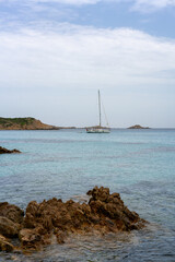 Fototapeta premium Scenic view of a sailboat anchored in the calm turquoise waters of Tuaredda Beach, Sardinia