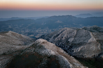 Fototapeta premium Drone view of mountain peaks glowing at sunset near Siniscola, Sardinia, Italy