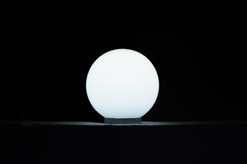 Illuminated light bulb against dark background