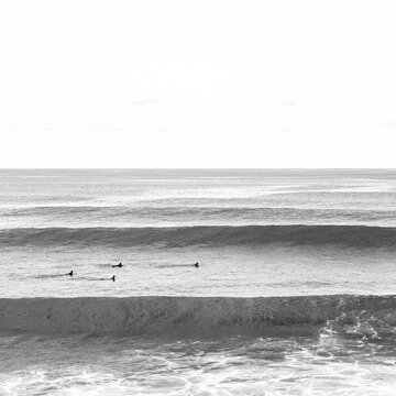Surfers swimming into the waves