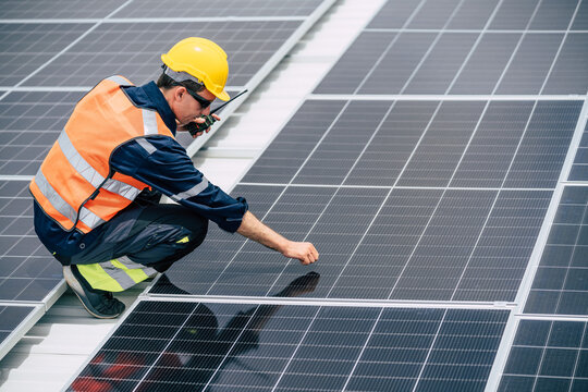 Worker inspects solar panels on a rooftop during daytime at a construction site - Powered by Adobe