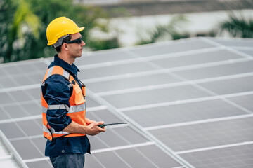 Obraz premium Worker inspects solar panels on a rooftop in a residential area during daylight hours