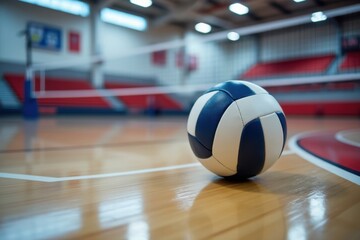 Volleyball resting on a polished wooden court in a brightly lit gymnasium