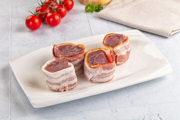 Raw pork tenferloin with bacon
