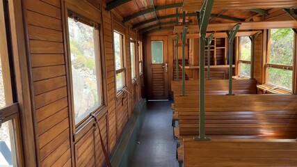 Vintage wooden train interior with sunlight streaming through windows, evoking nostalgia and adventure in travel enthusiasts
