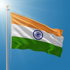 Waving Indian national flag on a flagpole against blue sky