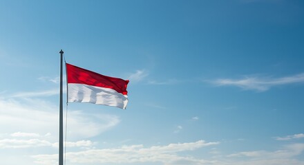 A realistic photo of Indonesian flag waving proudly under a blue sky