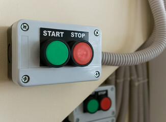 Close-up of control panel with start and stop buttons mounted on wall
