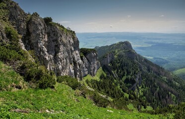 Panorama of spring mountain landscape with limestone rocks and lush green forest, blue sky. Spring hiking in the mountains, nature reserve. High Tatras, cottage Plesnivec