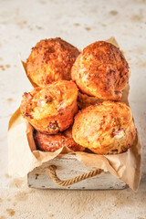 Savory egg muffins with bazil, ham and cheese in white wooden box on light textured background. Healthy and quick morning breakfast